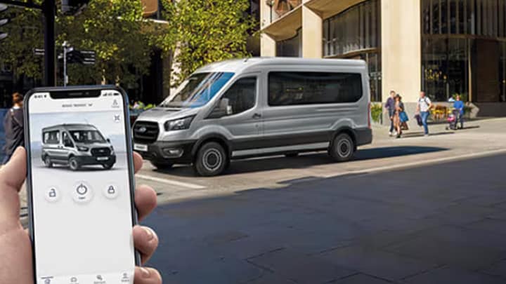 Pessoa com telefone celular usando o FordPass controlando sua Ford Transit e seus negócios.