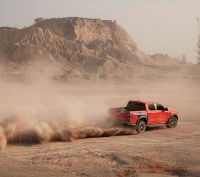 Ford Ranger Raptor laranja andando pelo deserto