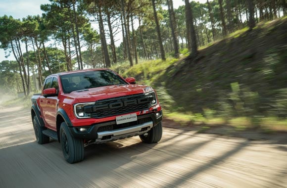 Novo Ranger Raptor laranja andando em estrada de terra